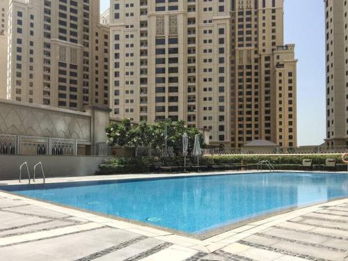 a large swimming pool in front of tall buildings at Frank Porter - Marina Promenade in Dubai