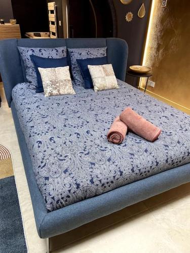 - un lit bleu avec 2 oreillers au-dessus dans l'établissement « Bulles de Bonheur », à Cherbourg en Cotentin