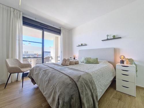 a white bedroom with a bed and a large window at Los Alcazares Velapi - 3610 in San Javier