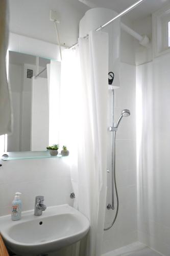 a white bathroom with a shower and a sink at City Apartment in bester Lage in Wolfsburg