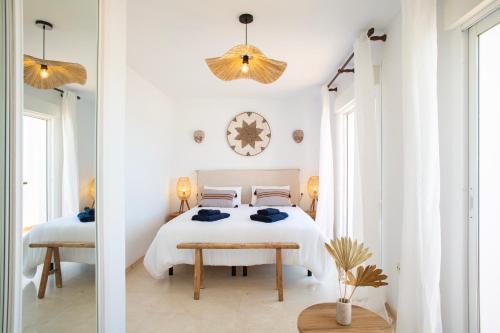 um quarto branco com uma cama e um espelho em Charming penthouse with sea views in Mijas pueblo em Mijas