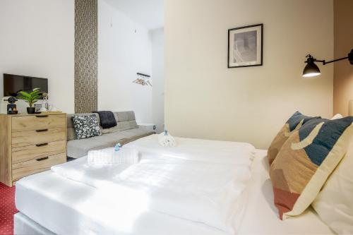 a living room with a white bed and a couch at Maverick Downtown in Budapest