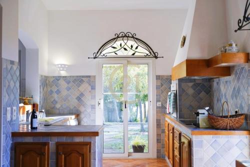 a kitchen with a door leading to a patio at Villa Santa Reparata di Balagna in LʼÎle-Rousse