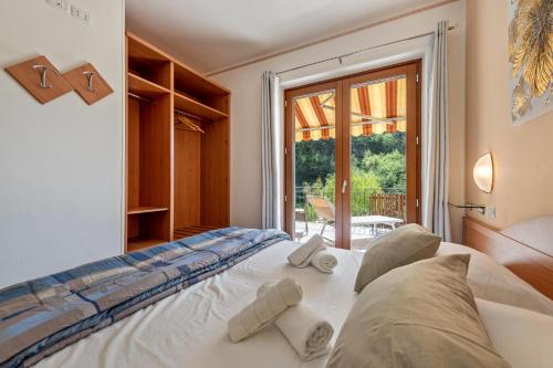 1 dormitorio con 1 cama blanca grande y ventana en Residence Tatiana A1, en Tremosine Sul Garda