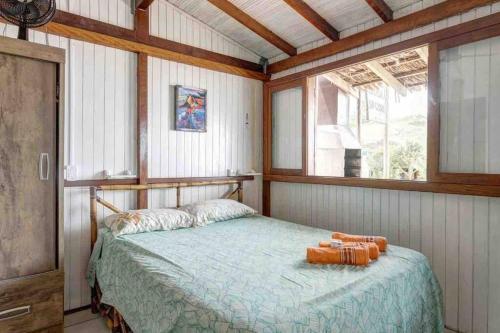 1 dormitorio con cama y ventana en Toca da Garoupa, en Laguna