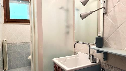 baño con lavabo y lámpara en K03 - Castelfidardo, ampio quadrilocale comodo ai servizi, en Castelfidardo