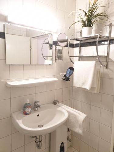 a white bathroom with a sink and a mirror at Wiesenweg W06 D in Laboe