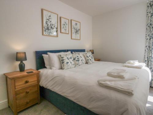 une chambre avec un grand lit et une table de chevet dans l'établissement Dalegarth Hall Farm Cottage 2, à Holmrook