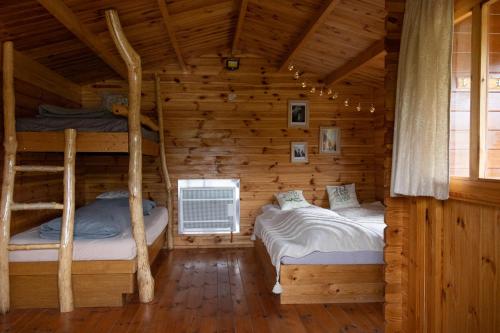 two bunk beds in a log cabin at Cozy wood hut on the farm in Třebívlice