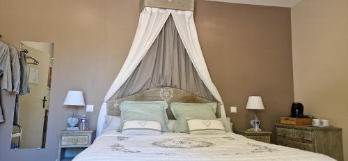 a bedroom with a large bed with a canopy at Le Miroir des Etoiles in Pomport