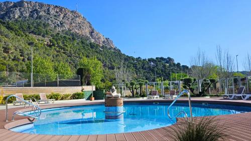 ein Schwimmbad mit einer Statue vor einem Berg in der Unterkunft Apartamentos La Masia in L'Estartit