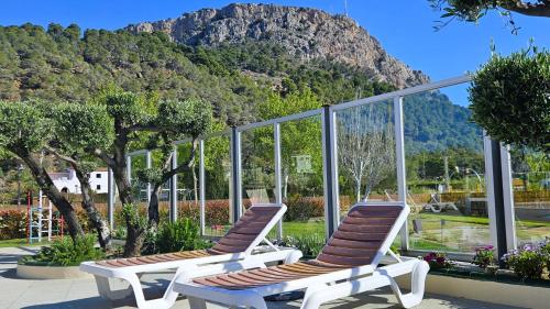 two lounge chairs sitting in front of a mountain at Apartamentos La Masia in L'Estartit