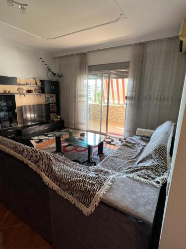 een woonkamer met een bed en een tafel bij Lindi's Guest House in Kamëz