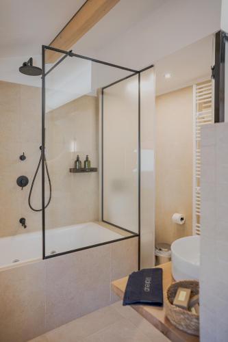 a bathroom with a shower with a tub and a sink at 1050 Mountain Living in Pavliani