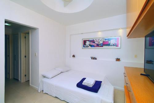 a white room with a bed and a picture on the wall at Quarto&Sala a 150m da Praia | U052 in Rio de Janeiro