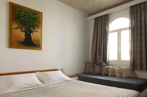 a bedroom with a bed and a window at Vallas Apartments & Villas in Firostefani