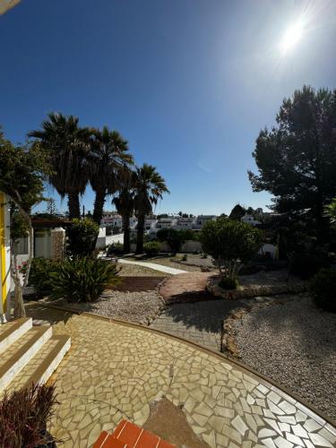 a stone walkway with palm trees in a yard at Vila Horizonte in Carvoeiro