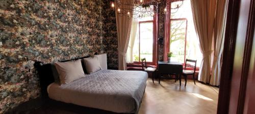 a bedroom with a bed and a wall with flowers at Pastorie Waaxens in Waaxens