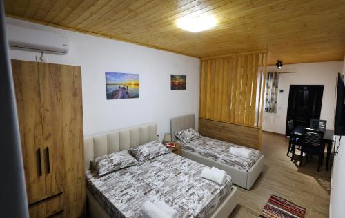 a bedroom with two beds and a dining room at Olive Oasis Studio in Berat