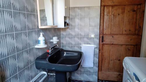 a bathroom with a black sink and a mirror at Casale Ariella Patricio in Mombaroccio