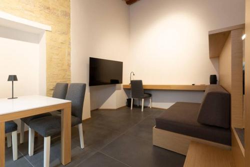 a room with a table and chairs and a television at Monolocale 201 Perugia in Perugia