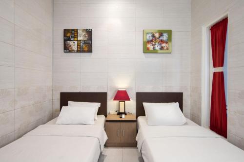 Llit o llits en una habitació de Angkul Angkul Beach Inn Kuta by Kamara