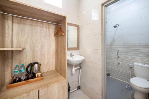 a bathroom with a toilet and a sink and a shower at Angkul Angkul Beach Inn Kuta by Kamara in Kuta