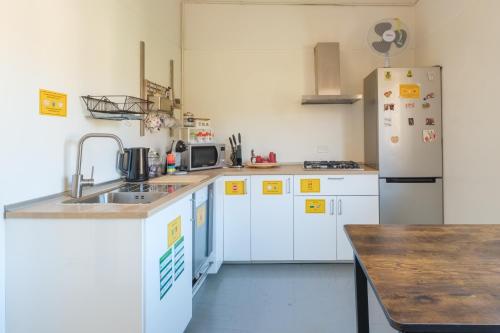 a kitchen with a sink and a refrigerator at Ostello Umile in Bologna