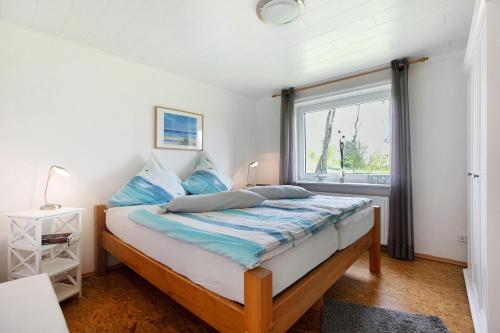 a bedroom with a bed with blue pillows and a window at Ferienhaus Krüger in Dörphof