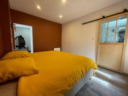 - une chambre avec un lit jaune et une fenêtre dans l'établissement Beauregard, à Bouxières-aux-Dames