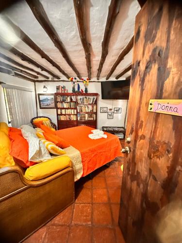 a bedroom with a bed with an orange comforter at Rancho Rebecca, villa de lujo para un Max 10 personas, vistas panorámicas playa y montañas, piscina, 5 H, 5 B en Guarame, Isla de Margarita in Flandes