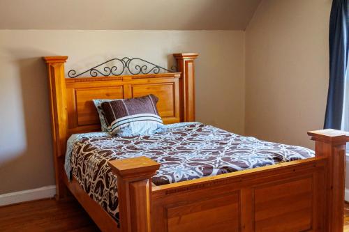 uma cama com uma estrutura de madeira e uma almofada em In the heart of the QC! em Charlotte
