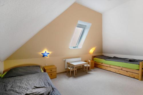 a attic bedroom with two beds and a table at Ferienwohnung Coni in Langballig