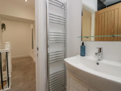 une salle de bain avec un lavabo et un miroir dans l'établissement Dalegarth Hall Farm Cottage 1, à Holmrook