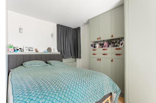 Schlafzimmer mit einem Bett mit blauer Decke in der Unterkunft Bastille nest in Paris in Paris