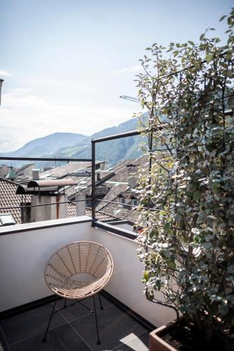 a chair sitting on a balcony with a view at Goldenstern Townhouse in Bolzano