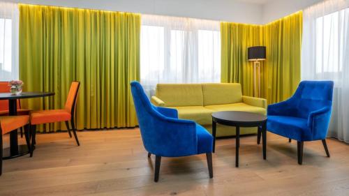 Thon Hotel Europa في أوسلو: غرفة معيشة مع أريكة وكراسي وطاولة