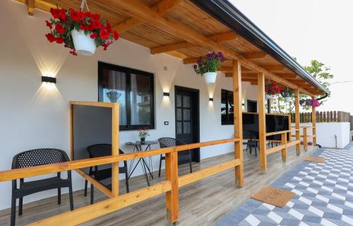 a deck with chairs and tables and flowers at Olive Oasis Studio in Berat