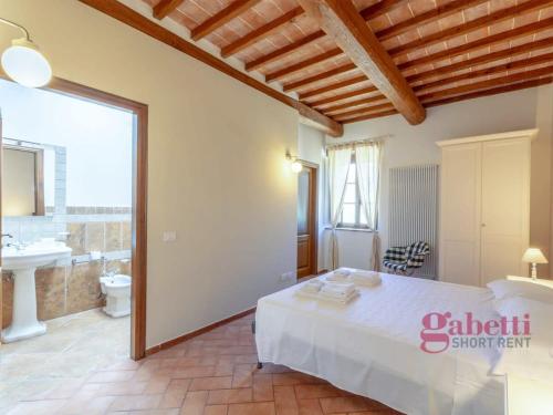 1 dormitorio con 1 cama y baño con lavamanos en Il Fienile - I Borghi Della Selvaccia en Cennina