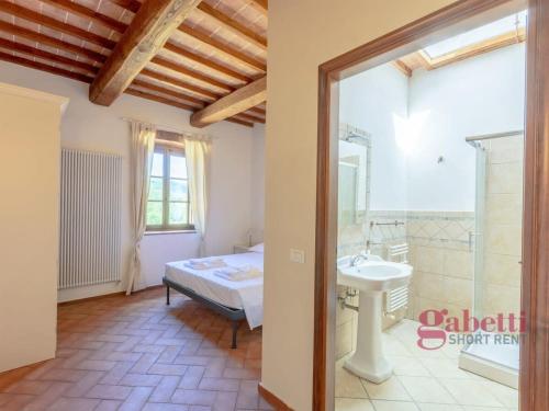 Habitación con baño con cama y lavabo. en Il Fienile - I Borghi Della Selvaccia en Cennina
