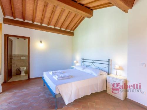 a bedroom with a bed and a bathroom with a toilet at La Filanda - I Borghi Della Selvaccia in Cennina