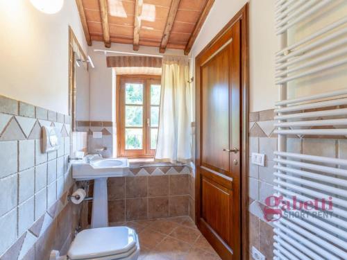 a bathroom with a toilet and a sink and a window at La Filanda - I Borghi Della Selvaccia in Cennina