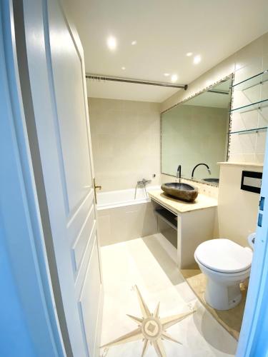 une salle de bain avec toilettes, lavabo et miroir dans l'établissement Domaine Juan Flore Studio Voilier, à Juan-les-Pins