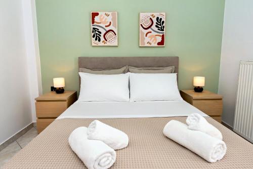 a bedroom with a bed with towels on it at Dioni Apartments in Plataria