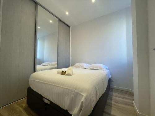 - une chambre avec un lit et un grand miroir dans l'établissement Charmant 2 pièces moderne centre ville -BEG-, à Cannes
