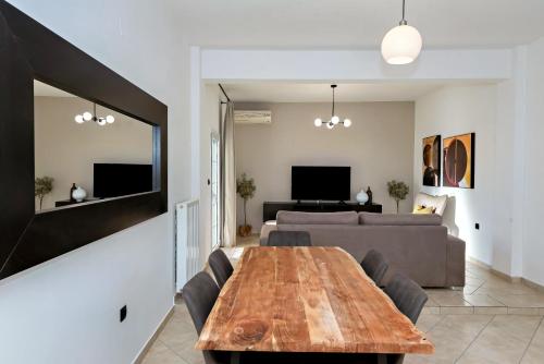 a living room with a wooden table and a couch at Dioni Apartments in Plataria