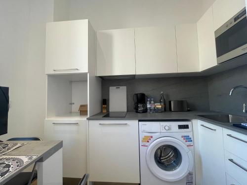 une cuisine blanche avec une machine à laver à l'intérieur dans l'établissement Charmant 2 pièces moderne centre ville -BEG-, à Cannes