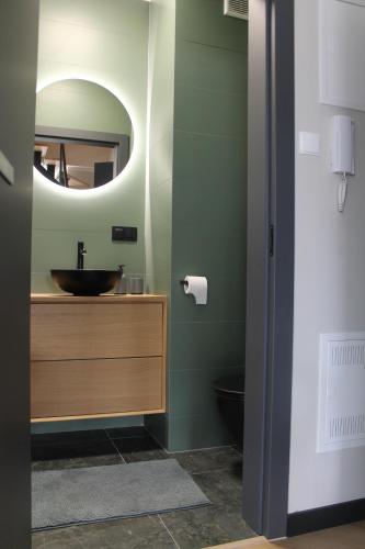 a bathroom with a sink and a mirror at Apartament przy Zodiaku in Mrągowo