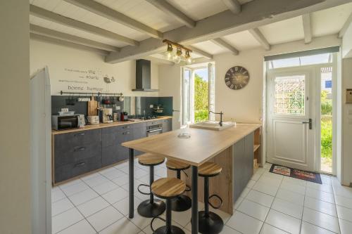 - une cuisine avec un comptoir et des tabourets dans l'établissement Maison à Cozes, à Cozes
