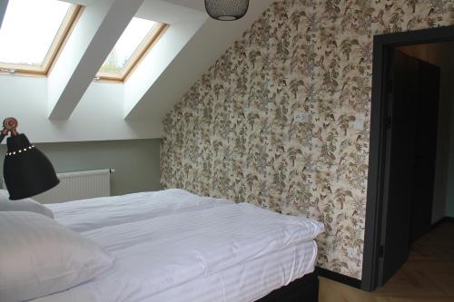 - une chambre avec un lit et un papier peint floral dans l'établissement Apartament przy Zodiaku, à Mrągowo